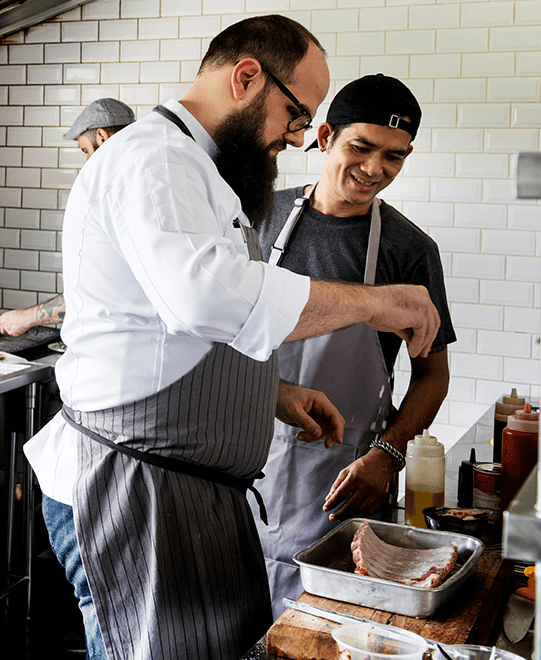 cooks-salting-ribs Two cooks sprinkling salt on ribs