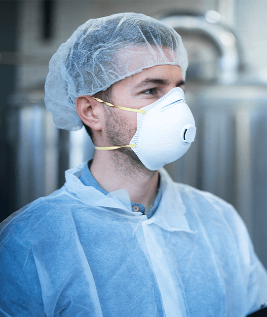 food-processing-technician Man wearing hair net, mask, and apron