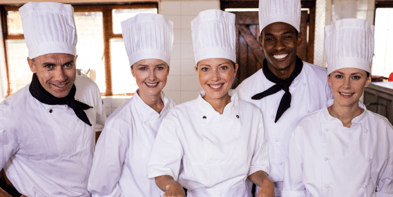section2 Five kitchen staff members who have food safety certification wearing chef uniforms.